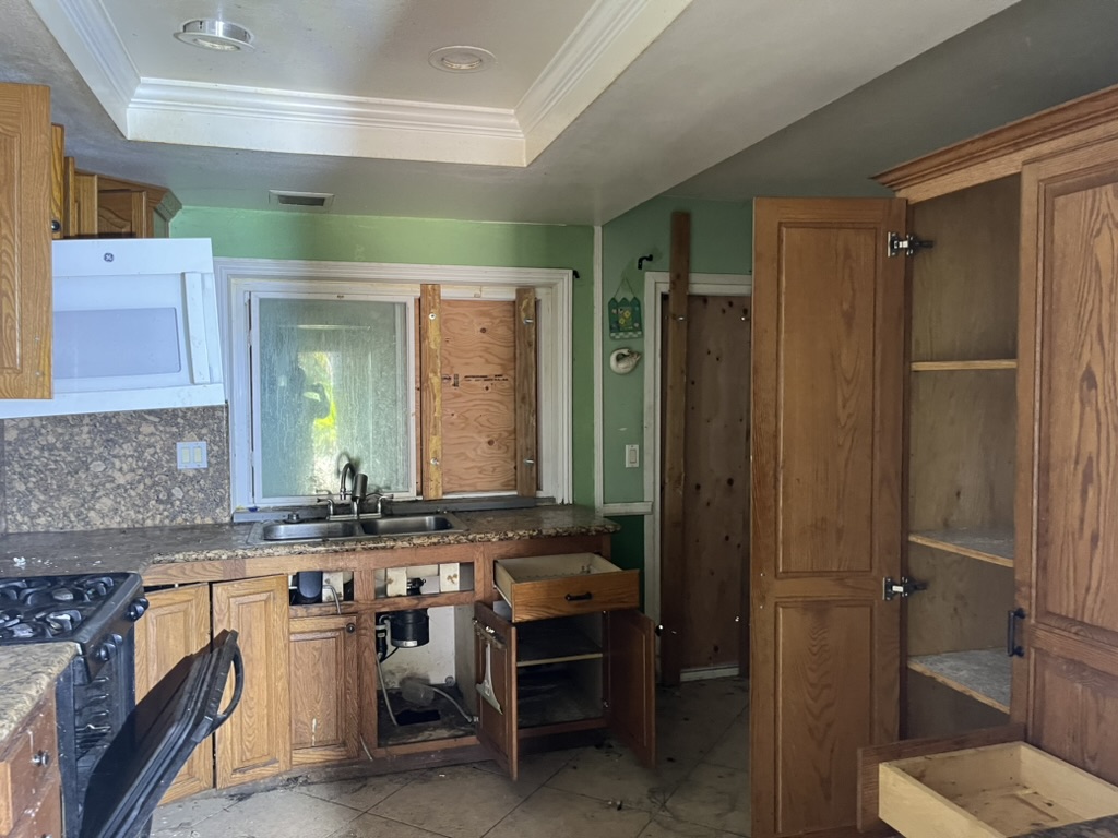 Briar Avenue kitchen before rehabilitation with open cabinets